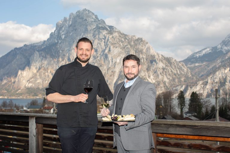 Käsesommelier Michael Pesendorfer (Gmundner Molkerei) und Paul Wieder (Inhaber ´s Paul Restaurant) am Balkon. Traunstein im Hintergrund.